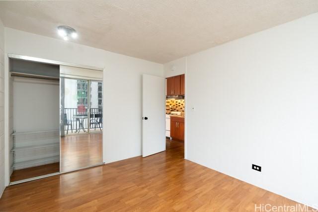 unfurnished bedroom with wood-type flooring and a closet