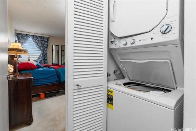 laundry area featuring stacked washer and dryer, carpet, and laundry area