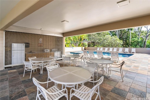 view of patio / terrace featuring a community pool and outdoor dining space