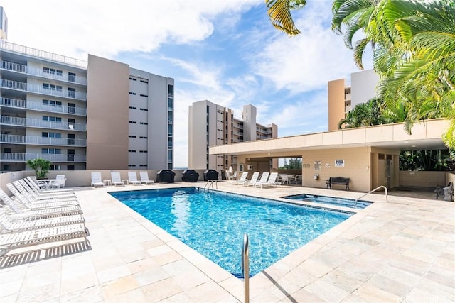 view of swimming pool with a patio and a hot tub