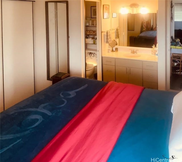 bedroom featuring ensuite bathroom and a sink