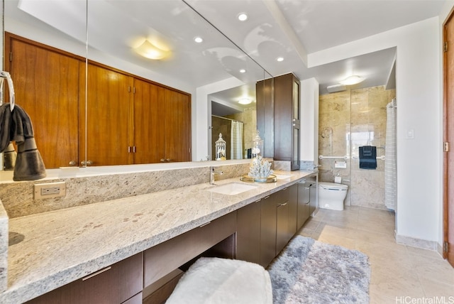 bathroom featuring tile patterned floors, vanity, a shower with shower door, and toilet