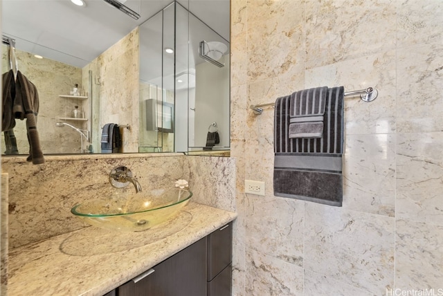 bathroom featuring vanity, tile walls, and tasteful backsplash