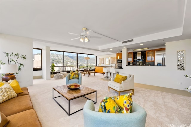 living room with light colored carpet and ceiling fan