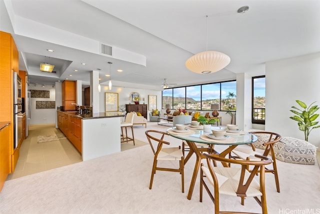 dining space featuring floor to ceiling windows, ceiling fan, and sink