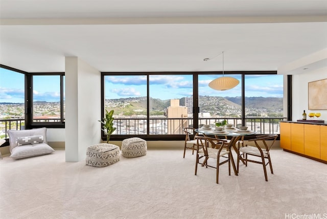 dining room featuring carpet, a mountain view, and floor to ceiling windows