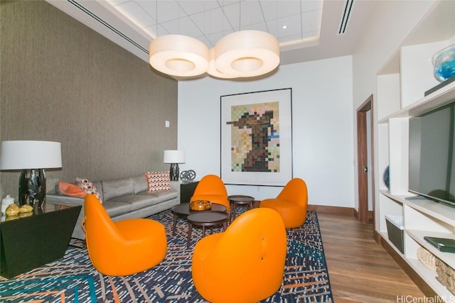 living room with hardwood / wood-style flooring and a tray ceiling