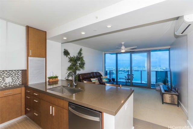 kitchen featuring ceiling fan, sink, stainless steel dishwasher, backsplash, and kitchen peninsula