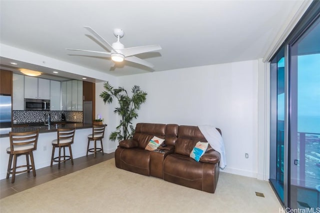 carpeted living room with ceiling fan