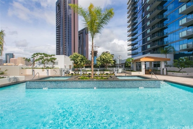 view of pool featuring a community hot tub and a patio