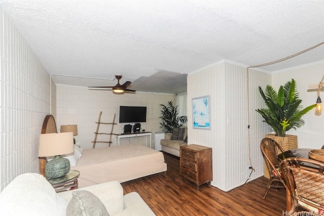 living room featuring a textured ceiling, ceiling fan, ornamental molding, and wood-type flooring