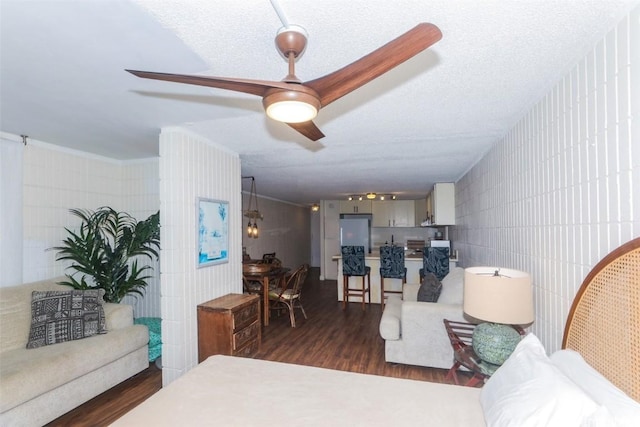 living room with a textured ceiling, dark hardwood / wood-style flooring, and ceiling fan