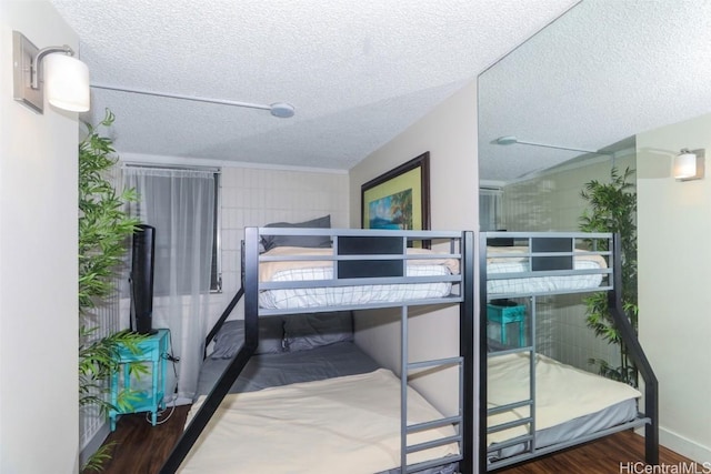 bedroom with a textured ceiling and dark hardwood / wood-style flooring