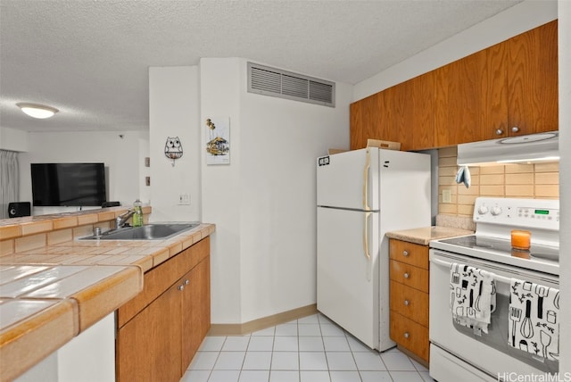 kitchen with tile counters, sink, tasteful backsplash, a textured ceiling, and white appliances