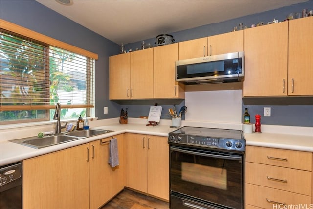 kitchen with light brown cabinets, sink, and black appliances