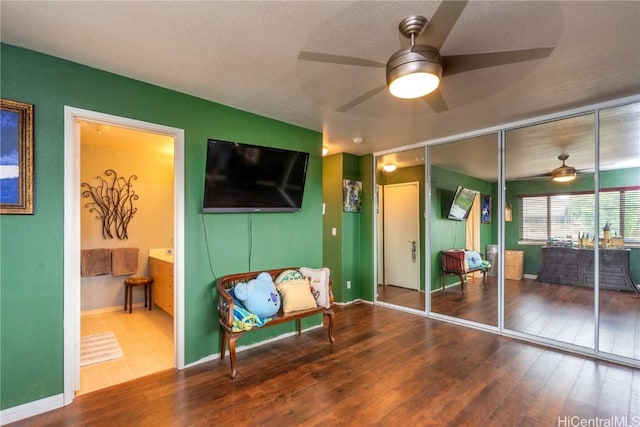 living area featuring ceiling fan and hardwood / wood-style flooring