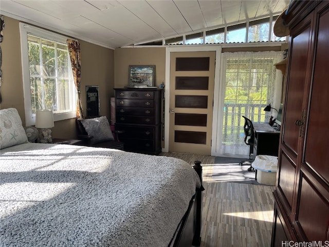 bedroom with vaulted ceiling and hardwood / wood-style flooring