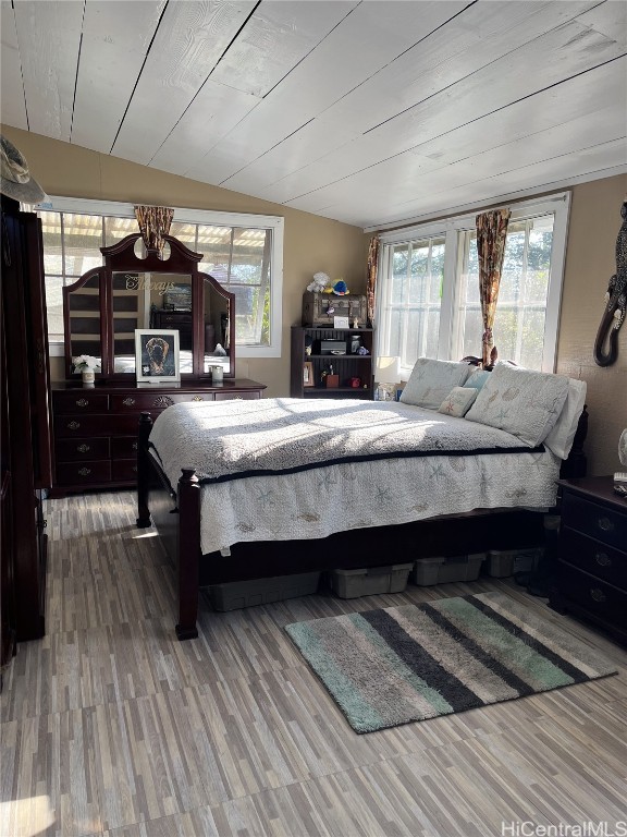 bedroom featuring wood-type flooring, vaulted ceiling, and wood ceiling