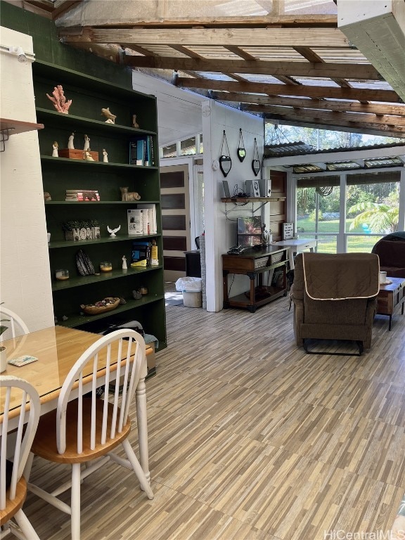 dining area with wood-type flooring and vaulted ceiling