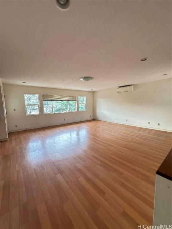 spare room with light hardwood / wood-style floors and a wall mounted air conditioner