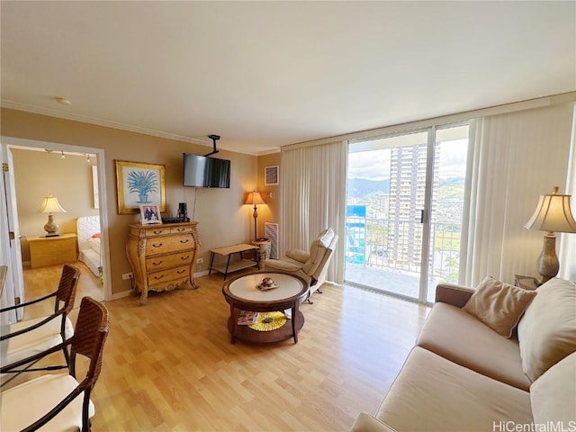 sitting room with crown molding, floor to ceiling windows, and wood-type flooring