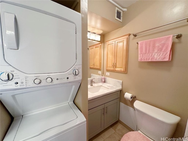 washroom featuring sink, stacked washer and dryer, and light tile patterned flooring