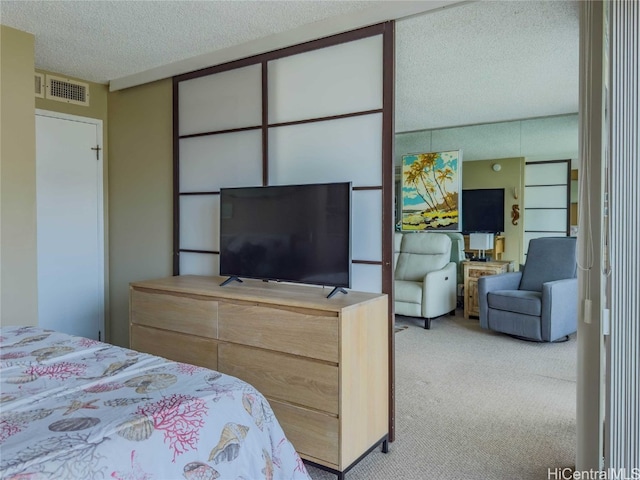 bedroom with a textured ceiling and light colored carpet