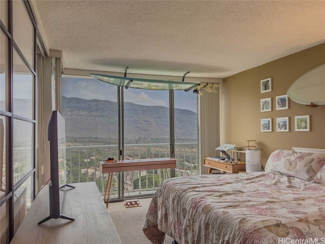 bedroom featuring floor to ceiling windows, carpet floors, and a textured ceiling