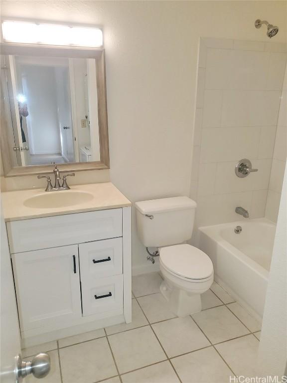 full bathroom featuring toilet, vanity, tile patterned flooring, and tiled shower / bath combo