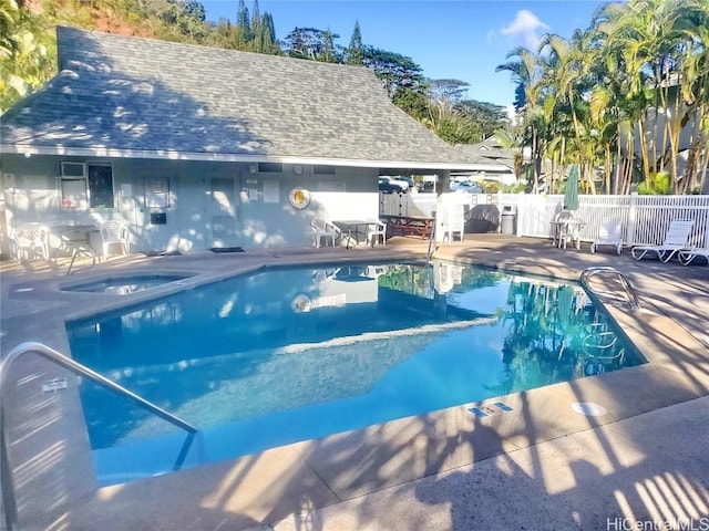 view of swimming pool featuring a patio area and a hot tub