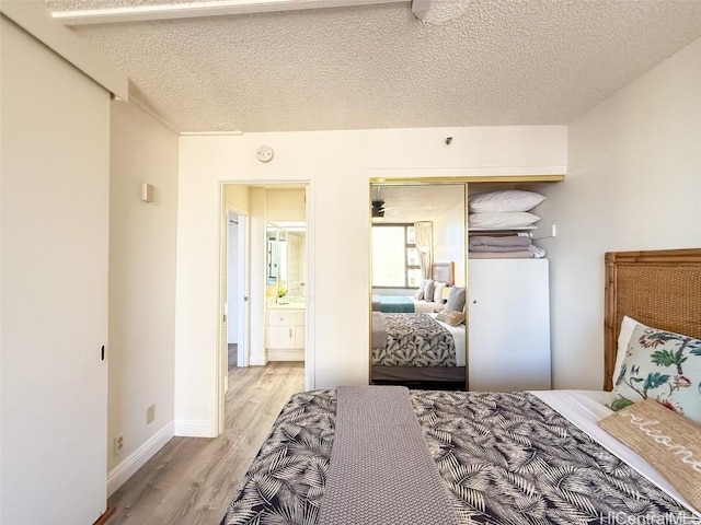 bedroom featuring a closet, a textured ceiling, and light wood-type flooring