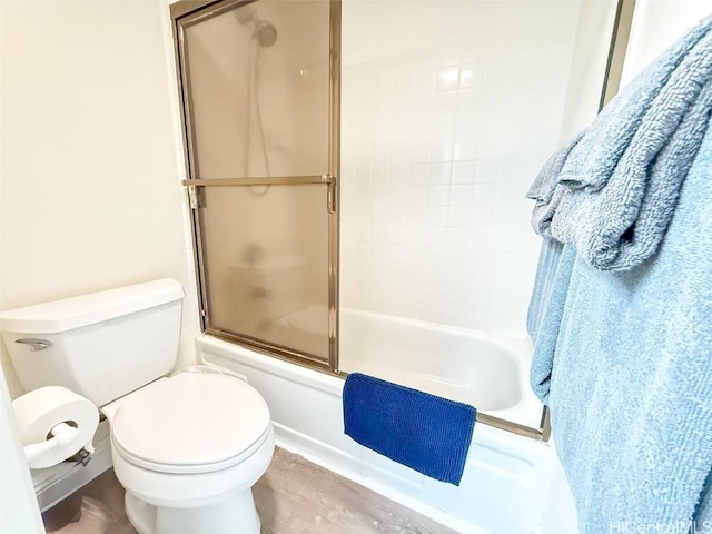 bathroom with combined bath / shower with glass door and toilet