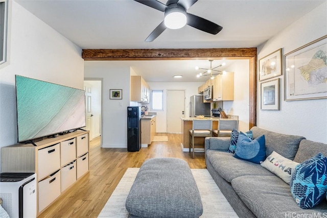 living room with sink, beamed ceiling, ceiling fan with notable chandelier, and light wood-type flooring