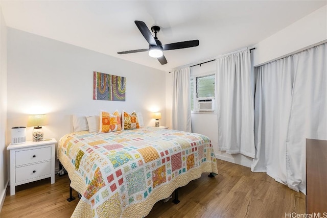 bedroom with ceiling fan, cooling unit, and light hardwood / wood-style floors