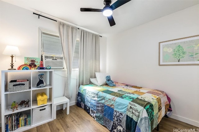 bedroom featuring wood-type flooring, ceiling fan, and cooling unit