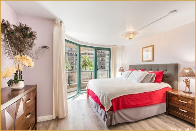 bedroom featuring access to outside, floor to ceiling windows, and light hardwood / wood-style flooring