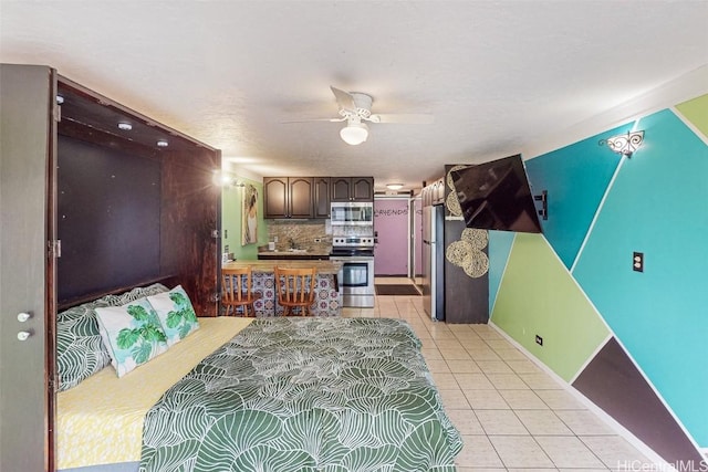 bedroom with light tile patterned floors, stainless steel fridge, and ceiling fan