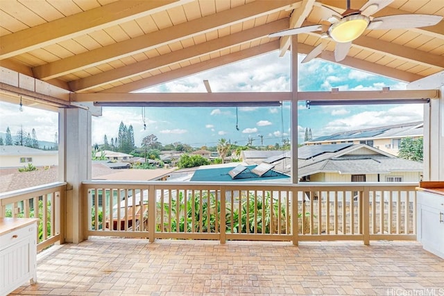 unfurnished sunroom with vaulted ceiling with beams, ceiling fan, and a residential view