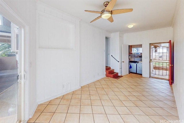 spare room featuring light tile patterned floors, ceiling fan, washer and clothes dryer, and stairs