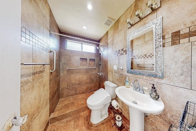 full bathroom with visible vents, tiled shower, toilet, tile walls, and recessed lighting