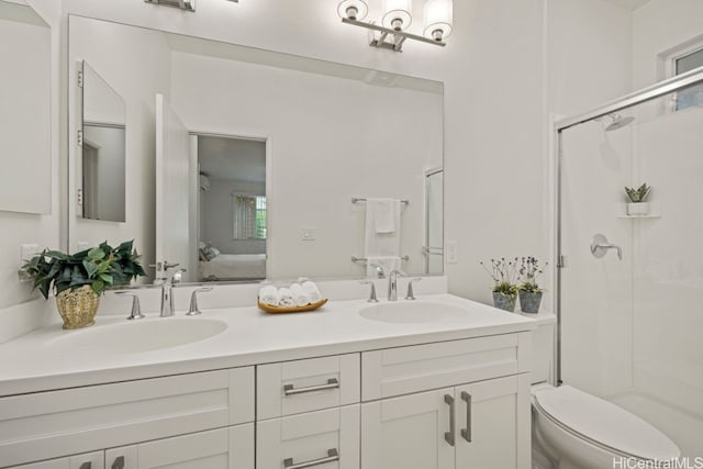 bathroom featuring vanity, an enclosed shower, and toilet