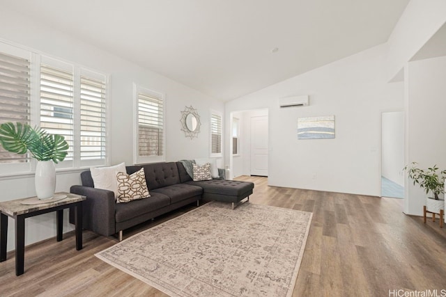 living room with light wood-type flooring, lofted ceiling, and an AC wall unit