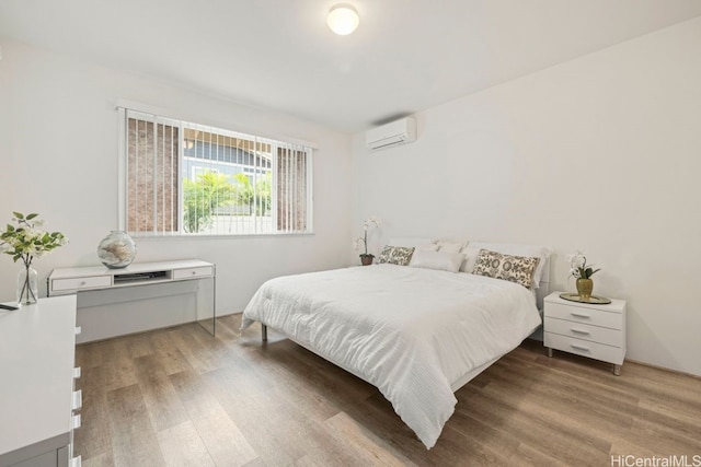 bedroom with a wall mounted AC and hardwood / wood-style flooring