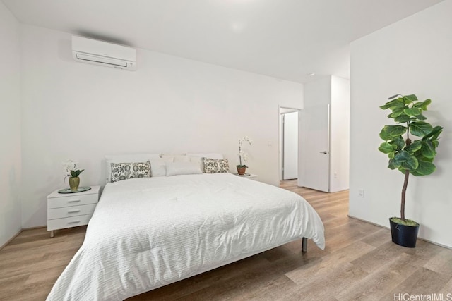 bedroom featuring an AC wall unit and light wood-type flooring