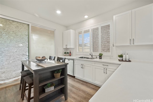 kitchen featuring dishwasher, white cabinets, light hardwood / wood-style floors, and sink