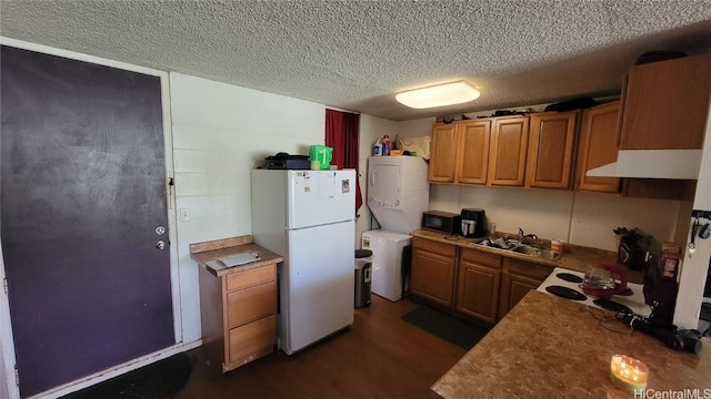 kitchen with a textured ceiling, sink, white refrigerator, dark hardwood / wood-style floors, and stacked washer / drying machine