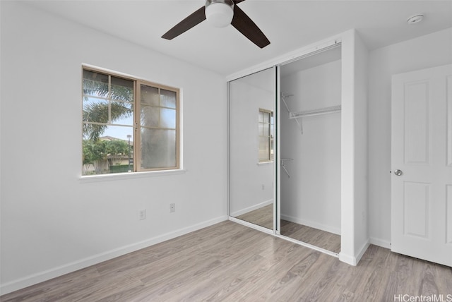 unfurnished bedroom with a closet, light hardwood / wood-style flooring, and ceiling fan