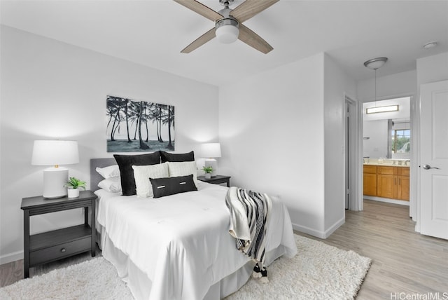 bedroom featuring connected bathroom, ceiling fan, and light hardwood / wood-style flooring