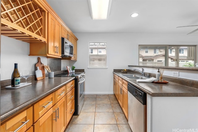 kitchen with light tile patterned flooring, stainless steel appliances, ceiling fan, and sink