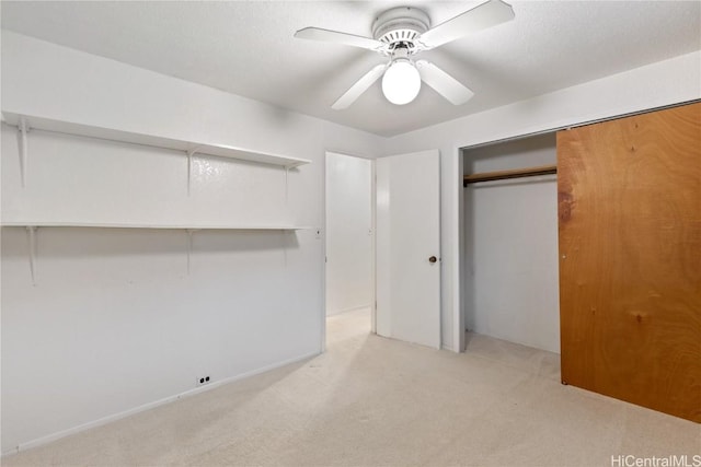 unfurnished bedroom featuring ceiling fan, a closet, and light carpet